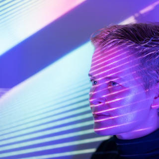 Viso di donna attraversato da luci per rilevamento dati biometrici per IA