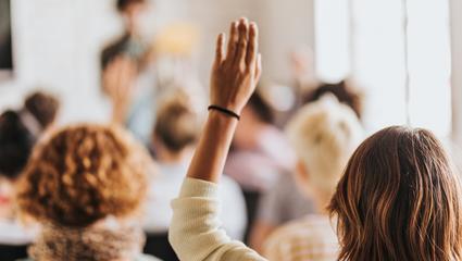donna che alza una mano per fare una domanda